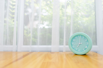 Light green alarm clock Placed on the table in the bedroom