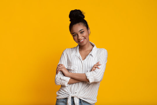 Beautiful Smiling Black Woman Posing With Folded Arms Over Yellow Background