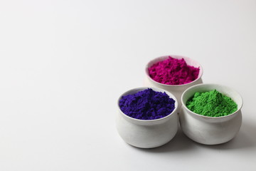 Set of Holi Colors placed in earthen platter with white backgroud (Holi Concept)