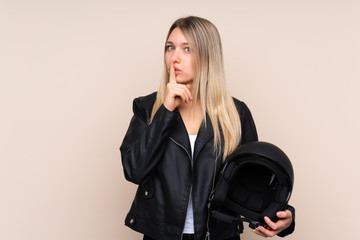 Young blonde woman with a motorcycle helmet over isolated background doing silence gesture