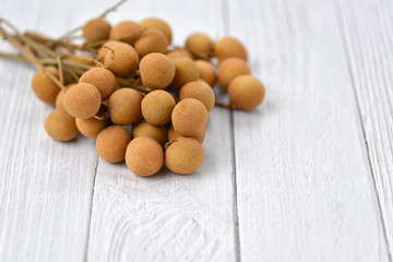 Longan Ripe (Dimocarpus longan) on a white wooden background. Fresh longan thai fruit. Healthy fruits, Soft selected focus.