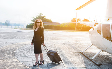 Business young woman in suit and wearing sunglass  dragging her luggage and walking away from...