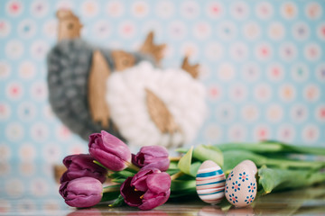 Easter decorations on a wooden background with flowers and eggs. 