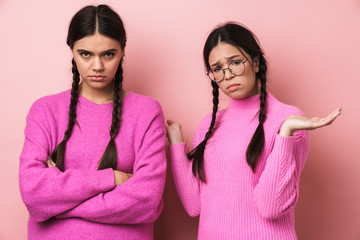Image of two offended teenage girls with braids standing with arms crossed