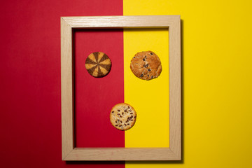 Wooden frame with cookies arranged inside, on a colored background. Space for copy-paste. Top view of a rectangular frame