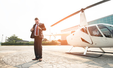 Confident old business man wearing sun glasses and suit walking away from helicopter to travel to work,aircraft of transportation of private company,Executive travel.Passenger of business elderly man,