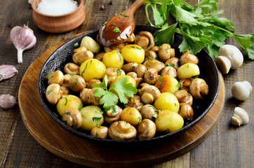 Delicious fried mushrooms with potatoes in cast iron pan