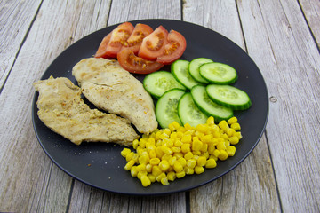 Chicken fillet with cucumbers, tomatoes and canned corn