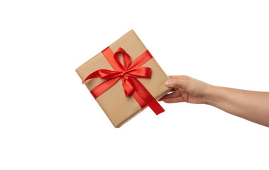 hand hold a wrapped gift in brown craft paper with tied silk red bows