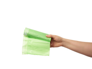 female hand holds a bundle of green plastic bags for garbage
