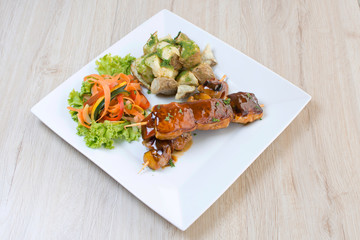 Pork skewer, accompanied by spicy potatoes and vegetables