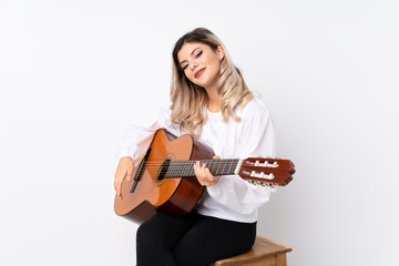 Teenager girl with guitar over isolated white background smiling a lot