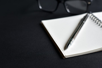 Focus view of Pen tip with book on black background.