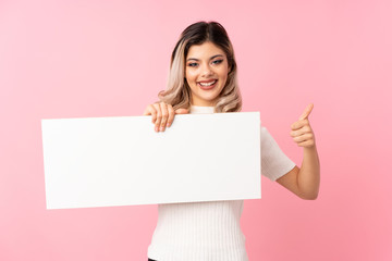 Fototapeta premium Teenager girl over isolated pink background holding an empty white placard for insert a concept