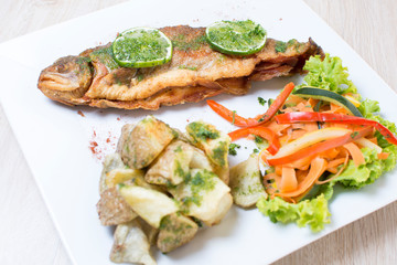 Baked trout, stuffed with ham and cheese, accompanied by spicy potatoes and vegetables