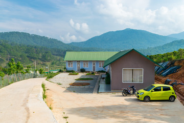 Transport near private houses in mountains and jungle in the background in tropics