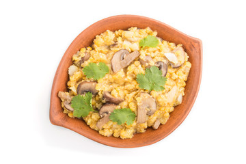 Lentils porridge with champignons. and coriander in a clay bowl isolated on white background. Top view.