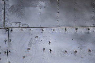 Aircraft skin close up. Rivets on gray metal.
