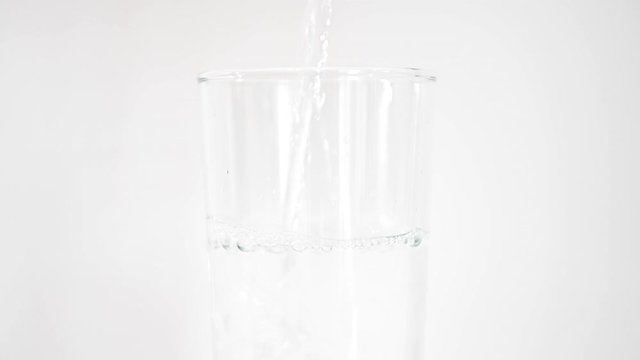 Fresh water being poured into a tall glass, on a white background, stock footage by Brian Holm Nielsen