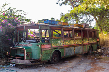 Old rusty bus partly collapsed in salvage yard