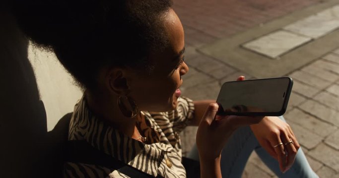 Mixed race woman talking on smartphone under bridge
