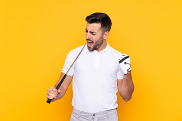 Man over isolated yellow background playing golf and celebrating a victory