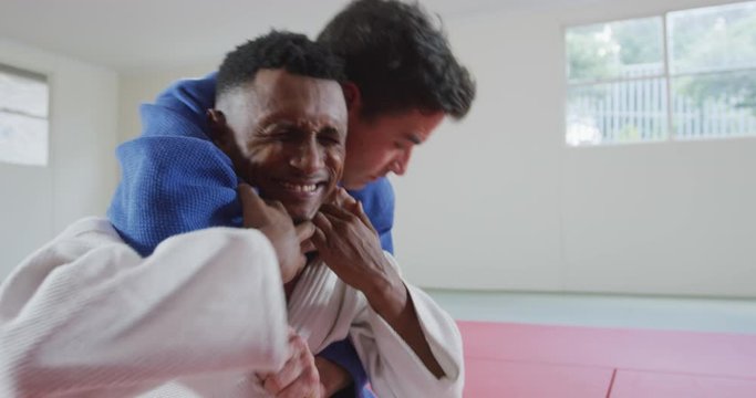 Judoka strangling his opponent on the judo mat