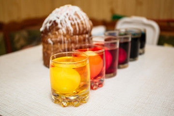Painting process of Easter eggs by dye in the glasses. Home decorations for the holiday.