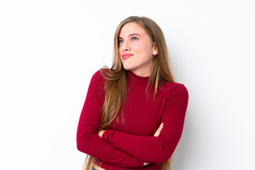 Teenager blonde girl over isolated white background making doubts gesture while lifting the shoulders