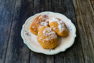 Mandazi is a slightly sweet East African Street Food; spicy, airy yeast doughnut dough made with coconut milk, flavored with cardamom and grated fresh coconut.