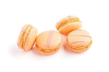 Orange macarons or macaroons cakes isolated on white background,  side view.