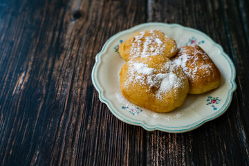 Mandazi is a slightly sweet East African Street Food; spicy, airy yeast doughnut dough made with coconut milk, flavored with cardamom and grated fresh coconut.