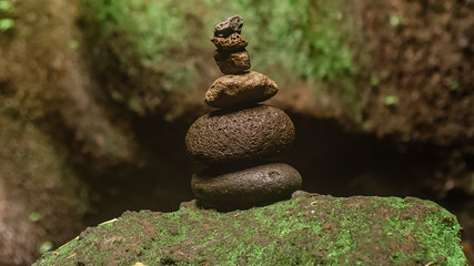 Stone pyramid in a ritual place in the soft green background to Spa ideas design or freedom and stability concept. Stone balance tower.