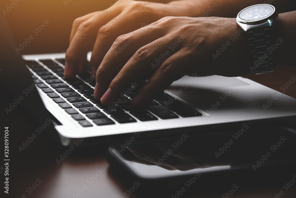 Poster closeup of a businessman hands working and typing on laptop keyboard