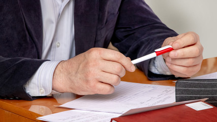 Businessman holds a pen for signing documents_