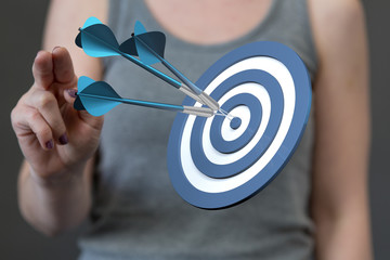 hand holding a target with darts hitting the center over white background. Concept of .