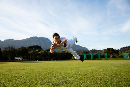 Cricket Player Trying To Catch A Cricket Ball On The Pitch