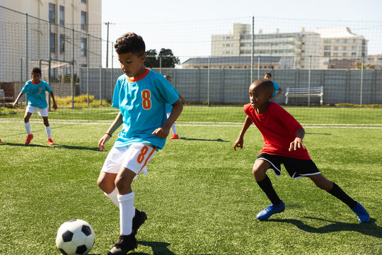 Fototapeta Children training to play soccer on the field