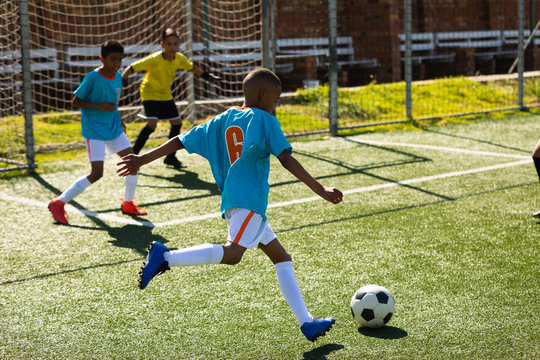 Fototapeta Child trying to score a goal