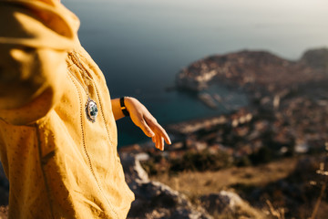 Close up of woman hands holding handmade embroider necklaces. Sea and old city of Dubrovnik in background.