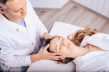 Obraz premium A young girl at the doctor of osteopath , to treat curvature of the spine.