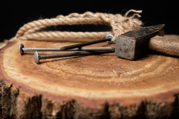 Nails, hammer and rope lie on a wooden board. Papa's Day, Papa's Holiday. Construction and repair