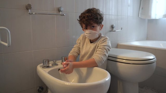 Italy , Milan - European white boy children quarantine with mask looks out the window of the house - contagion of the Novel Coronavirus 2019- ncov -  virus incubation isolation 