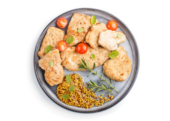 Fried pork chops with tomatoes and herbs on a gray ceramic plate isolated on white background. top view.