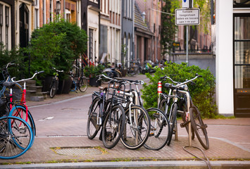 Fototapeta na wymiar Amsterdam city in Netherlands with bycicles beside a canal