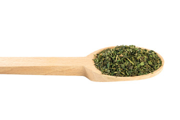dried nettle herb or in latin Utricae folium in wooden spoon isolated on white background....