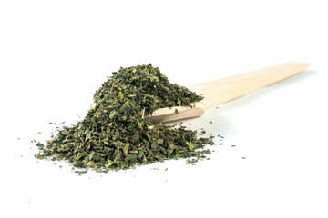 dried nettle herb or in latin Utricae folium in wooden spoon isolated on white background....
