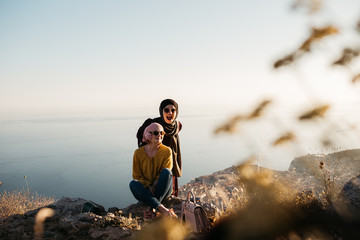 Lifestyle portrait of two best friends, smiling and having fun together. Outdoor photo of two young women, one with hijab, enjoying each other company with old city of Dubrovnik in background.