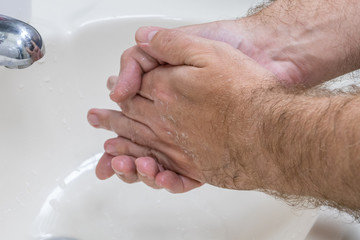 Fototapeta premium Man washing hands in basin close-up