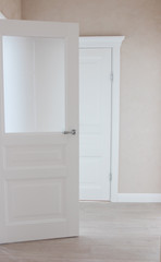 Fototapeta na wymiar Modern white door. Gray wall with free space. Minimalist bright interior